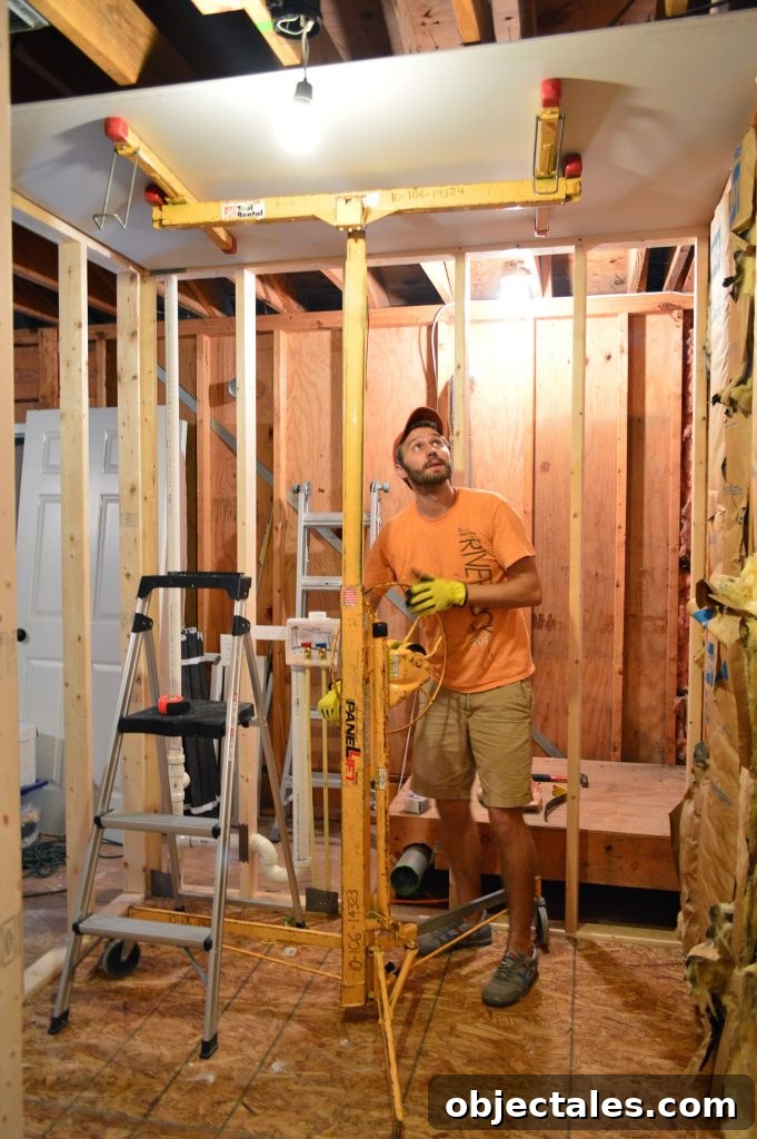 Hang Drywall Alone: Step-by-Step DIY Guide for One Person 4 John using drywall lift to hold sheet of sheetrock to ceiling