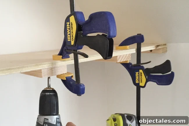 Screwing on a top plywood piece for thin floating shelves using Irwin Quick Grip clamps to hold the in place
