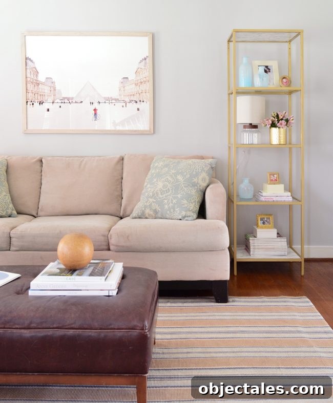neutral living room with gold shelves and large art