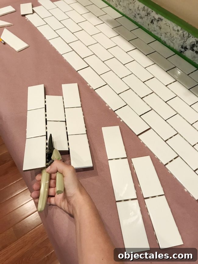 Sherry using scissors to cut tiles off subway tile sheet