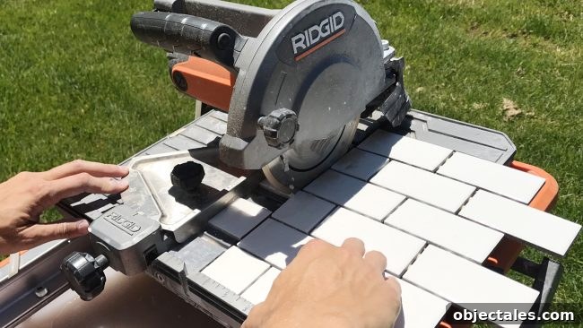 Ridgid wet saw cutting a sheet of small white subway tiles