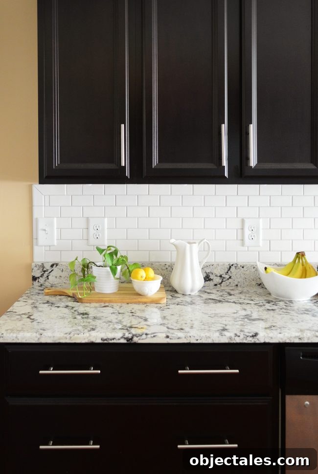 white subway tile sheet backsplash with black cabinetry
