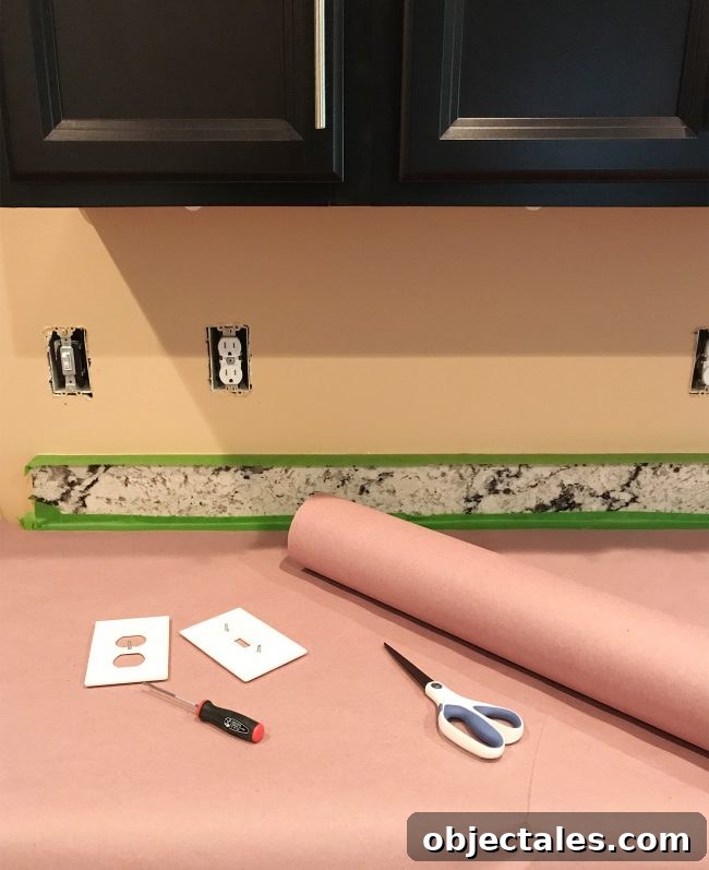 kitchen prepared for tiling with outlet covers removed and counters protected