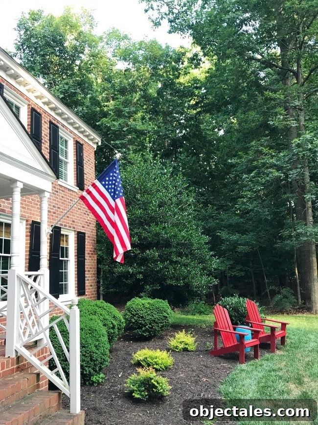 How We Planned Our Patriotic Front Porch and Yard 8 american flag on brick colonial home with red adirondak chairs