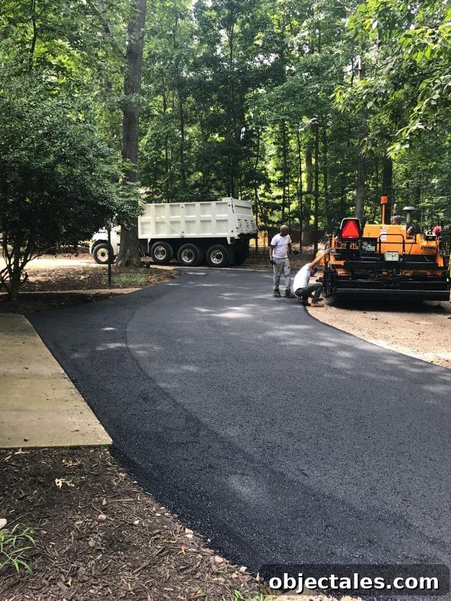 Crew finishing driveway paving