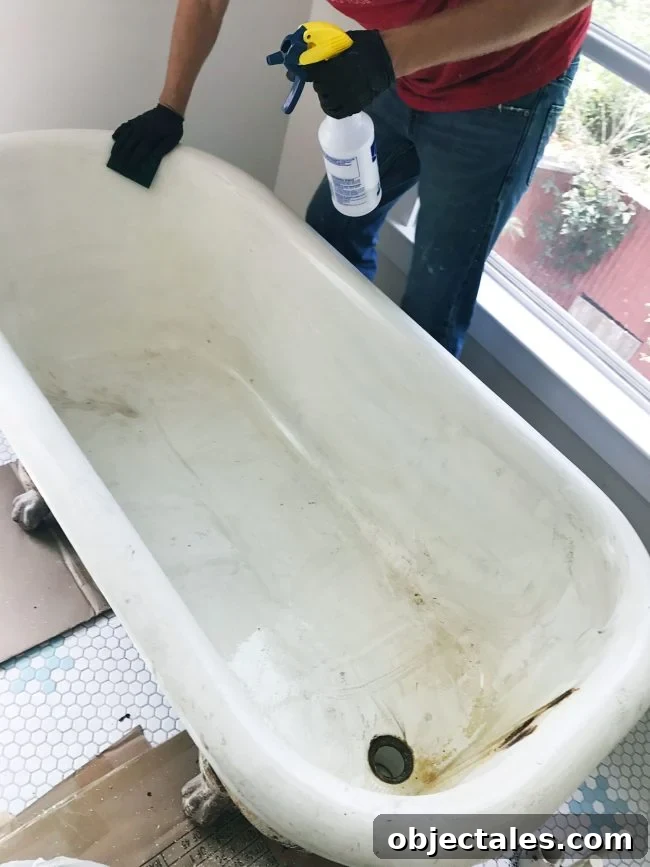 Refinish Your Old Clawfoot Tub: Step-by-Step Guide 8 Cleaning clawfoot tub with sponge and vinegar