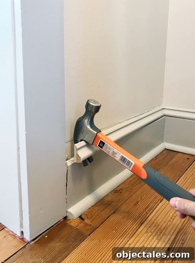 hammer prying off baseboard molding in pantry