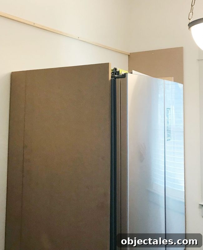 large MDF pieces added vertically against fridge in pantry