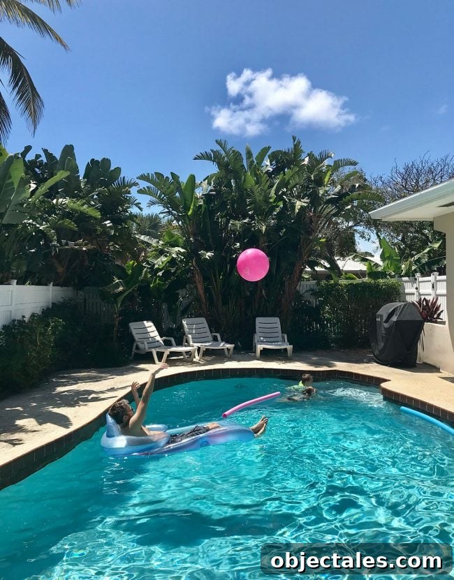 Family Spring Break in Fort Lauderdale: Our Trip Highlights 5 playing in the pool with palm trees around it at beach rental on terra mar island
