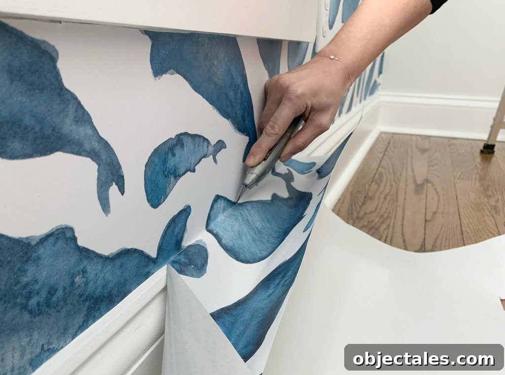 How to Install a Peel-and-Stick Wall Mural 15 Cutting Off Excess Peel-And-Stick Wallpaper Along Baseboard