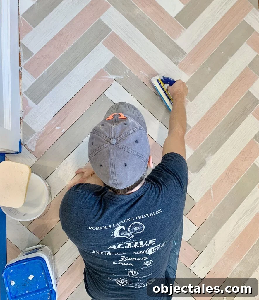 John grouting a colorful herringbone mudroom floor with mapei grout