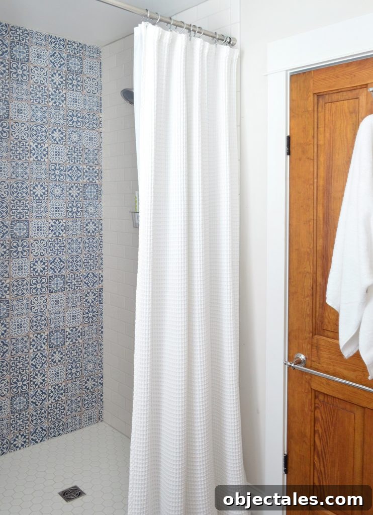Blue Accent Tile In Shower Of Hall Bathroom With Wood Door
