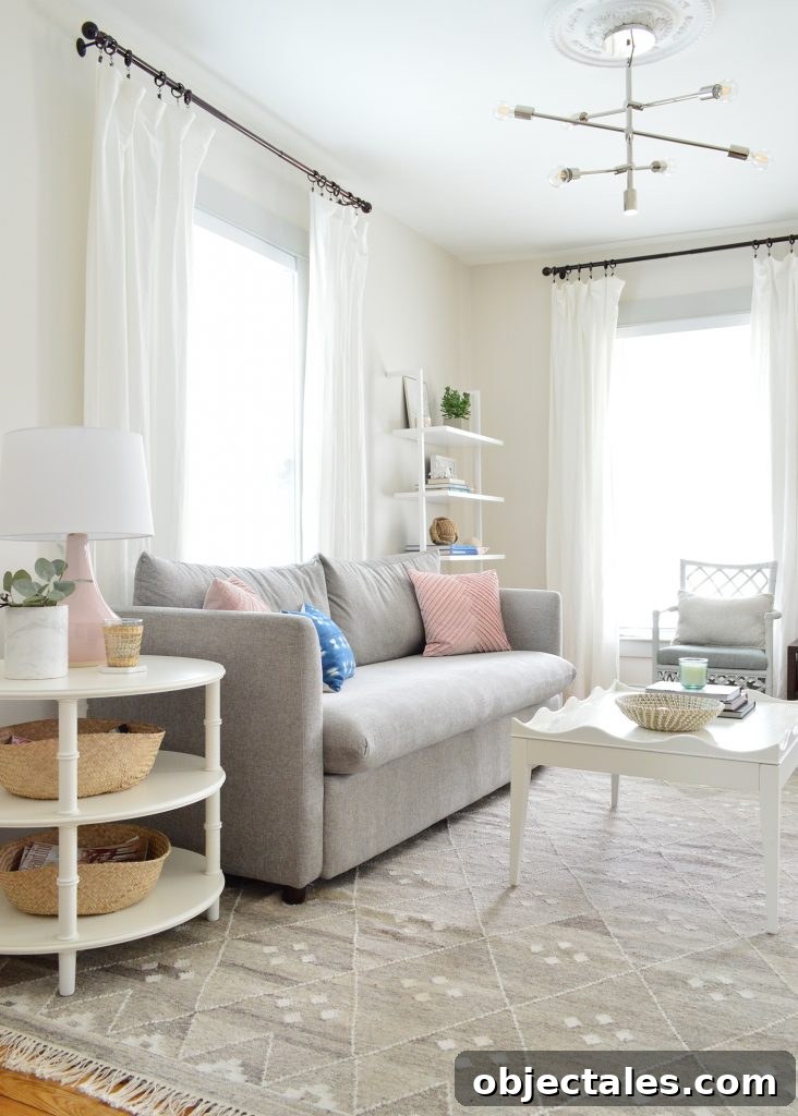bright neutral living room gray sofa with round side table and scalloped coffee table