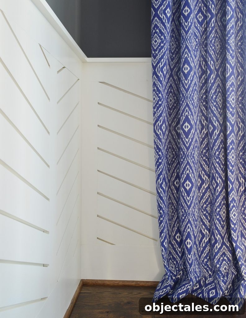 Chevron wainscotting with blue diamond curtain hanging to graze floor