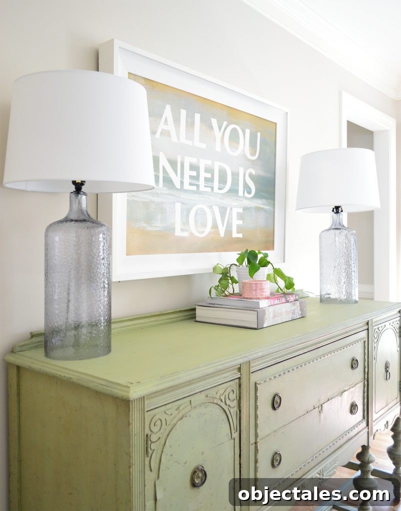 Low-Maintenance Houseplants and Lifelike Faux Alternatives 3 Dining room with vintage green buffet and green ivy plant under All You Need Is Love painting