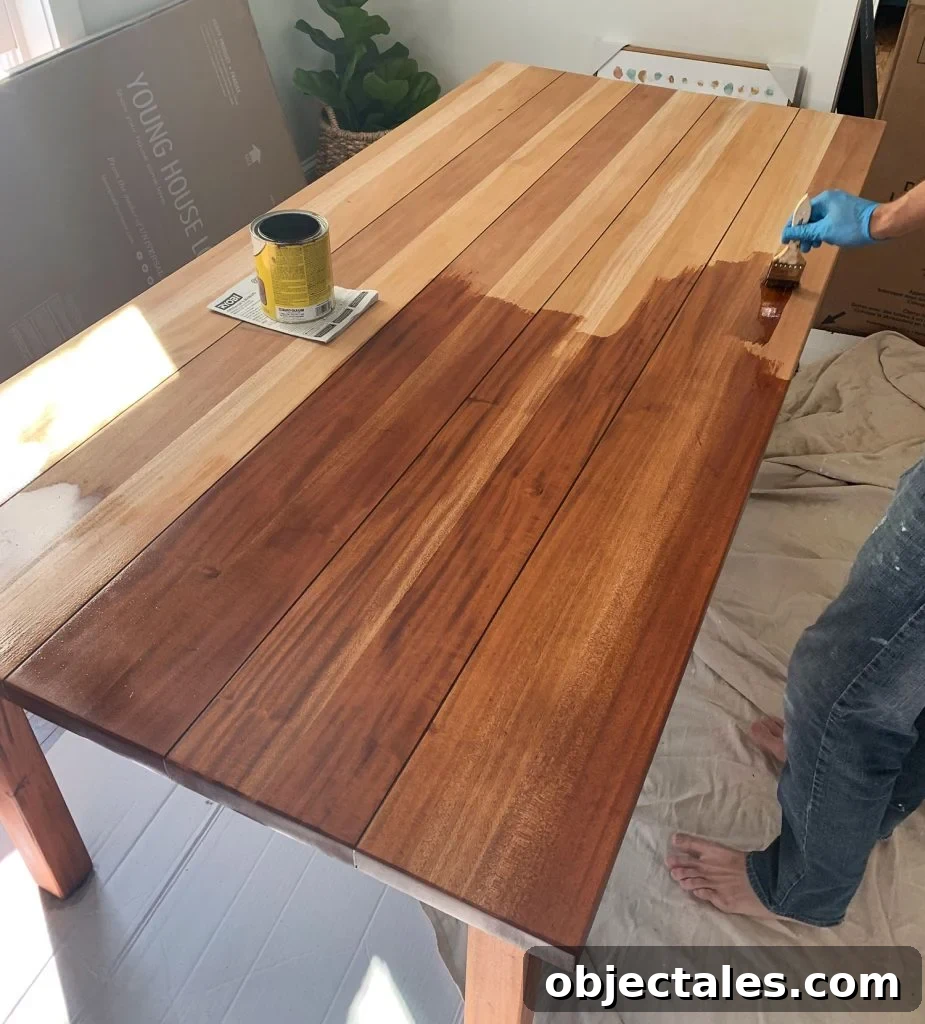 Refinish Your Table: Step-by-Step Guide to a Smooth Finish 14 Minwax Stain Being Applied To Wood Dining Table During Refinishing