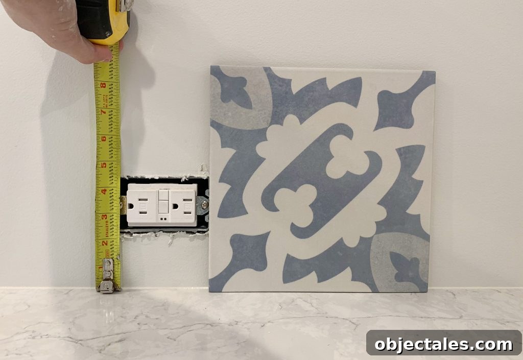 Checking Backsplash Tile Against Electrical Outlet In Kitchen