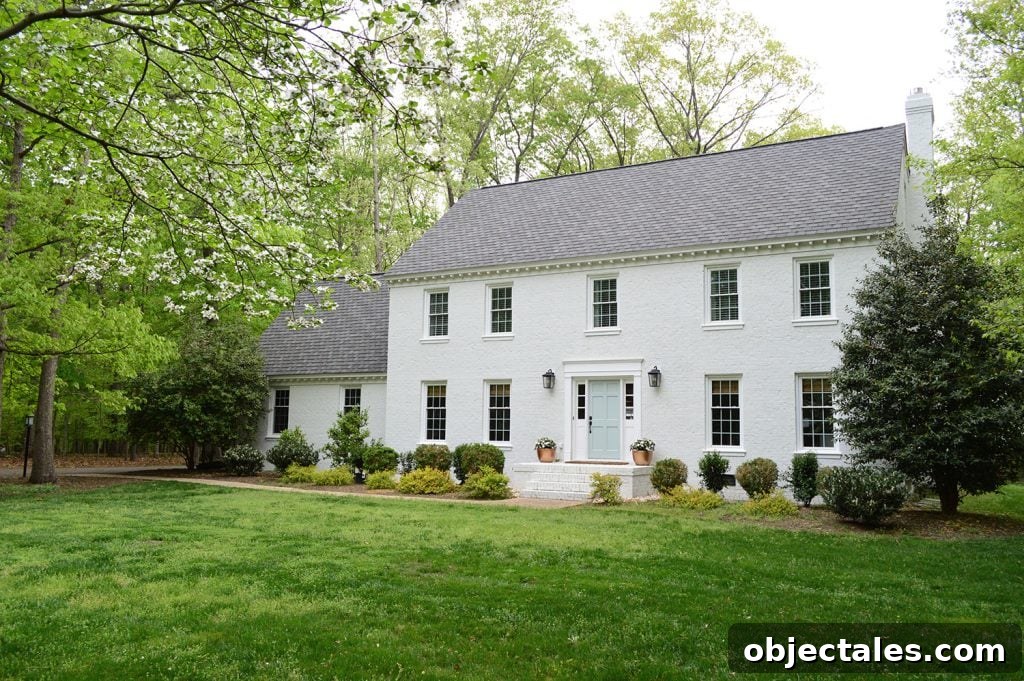 Our house with a white painted brick exterior and a white dogwood tree in front