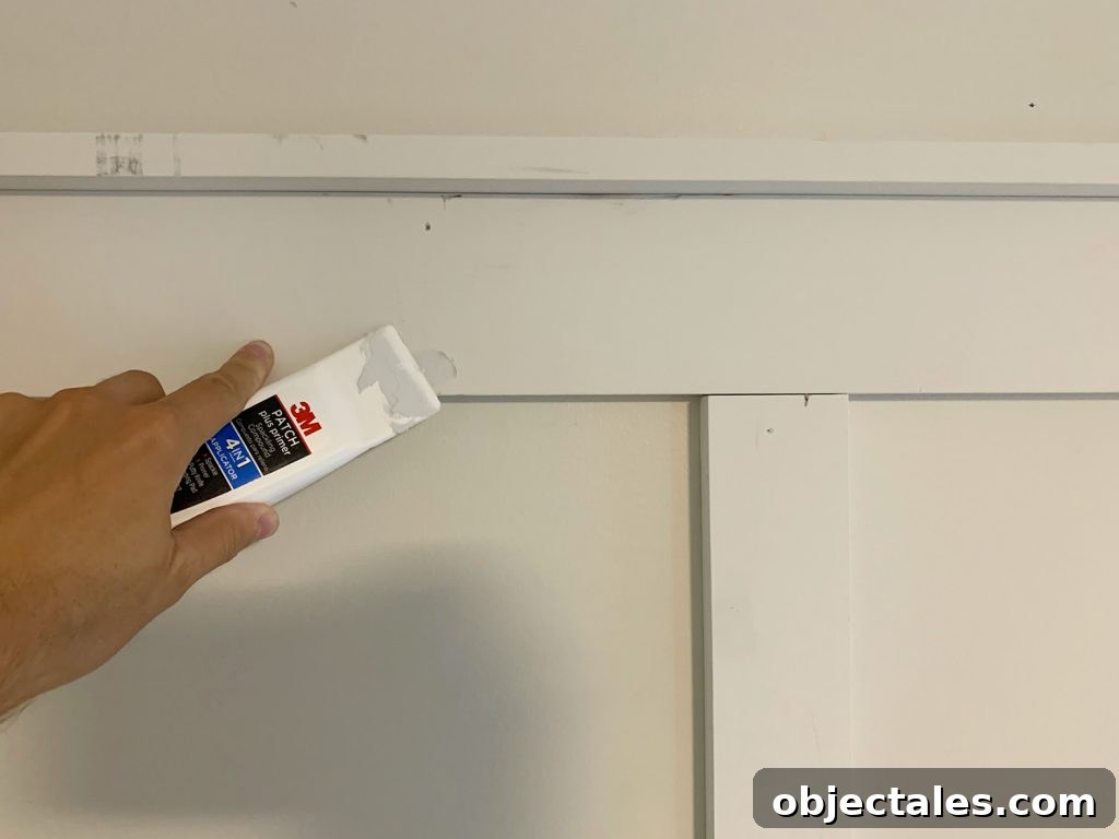 Using Spackling Tool To Fill Nail Holes On Board And Batten