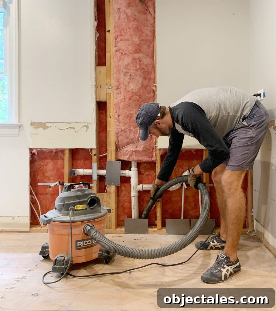 John Using Shop Vac To Remove Dust During Bathroom Renovation
