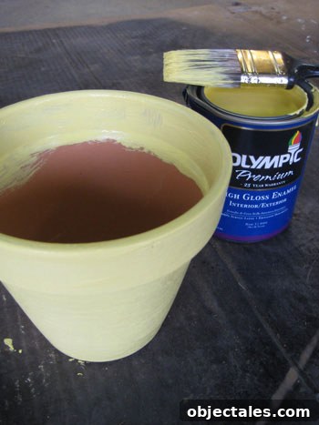 adding yellow paint to terra cotta pot
