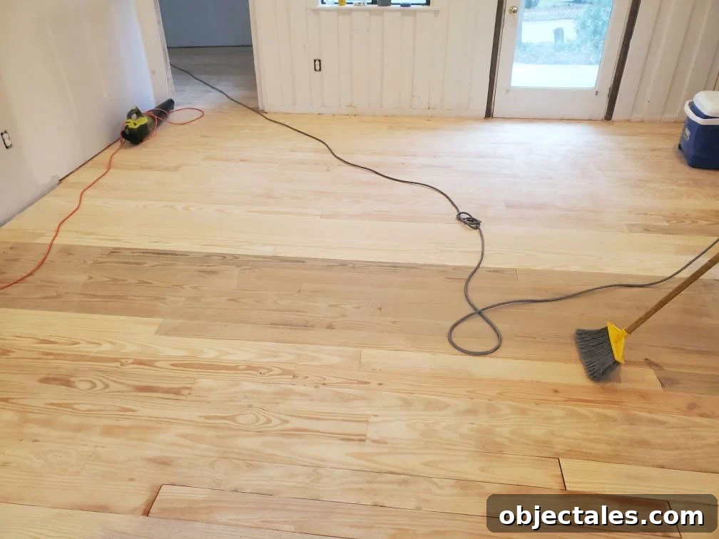 Sanded hardwood floors showing a long stripe of mismatched wood
