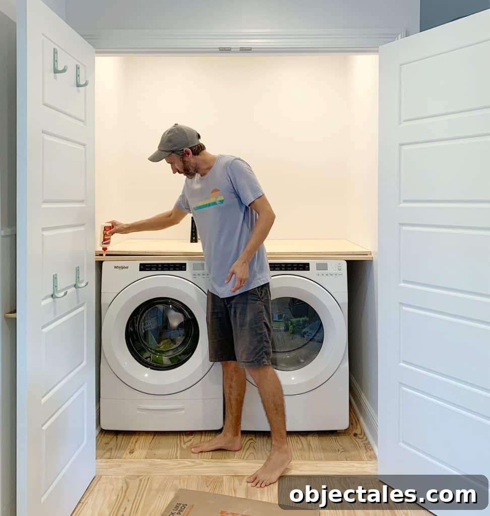 Man adding wood glue to front of laundry closet plywood counter