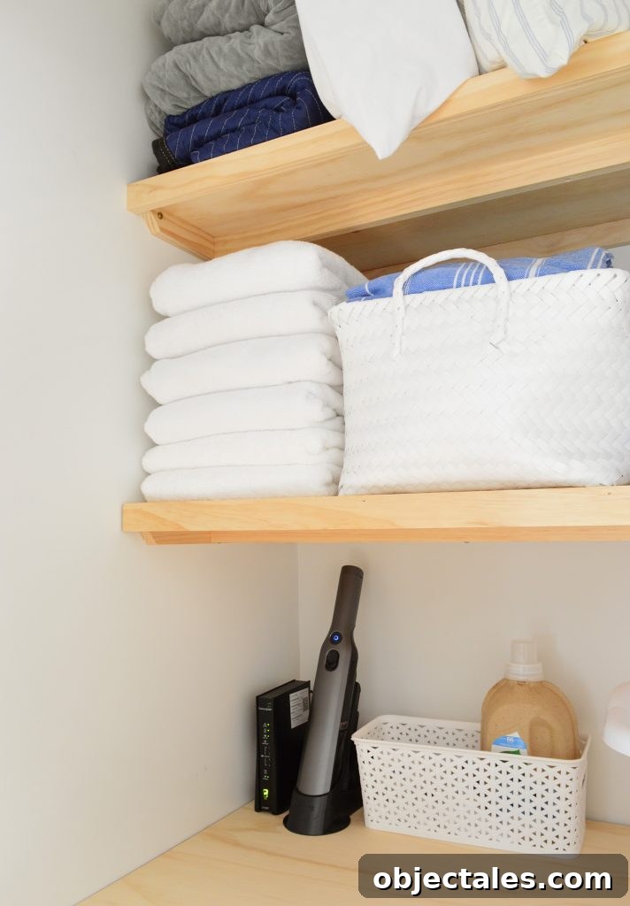Towels and baskets stored on wood laundry shelves with support braces underneath