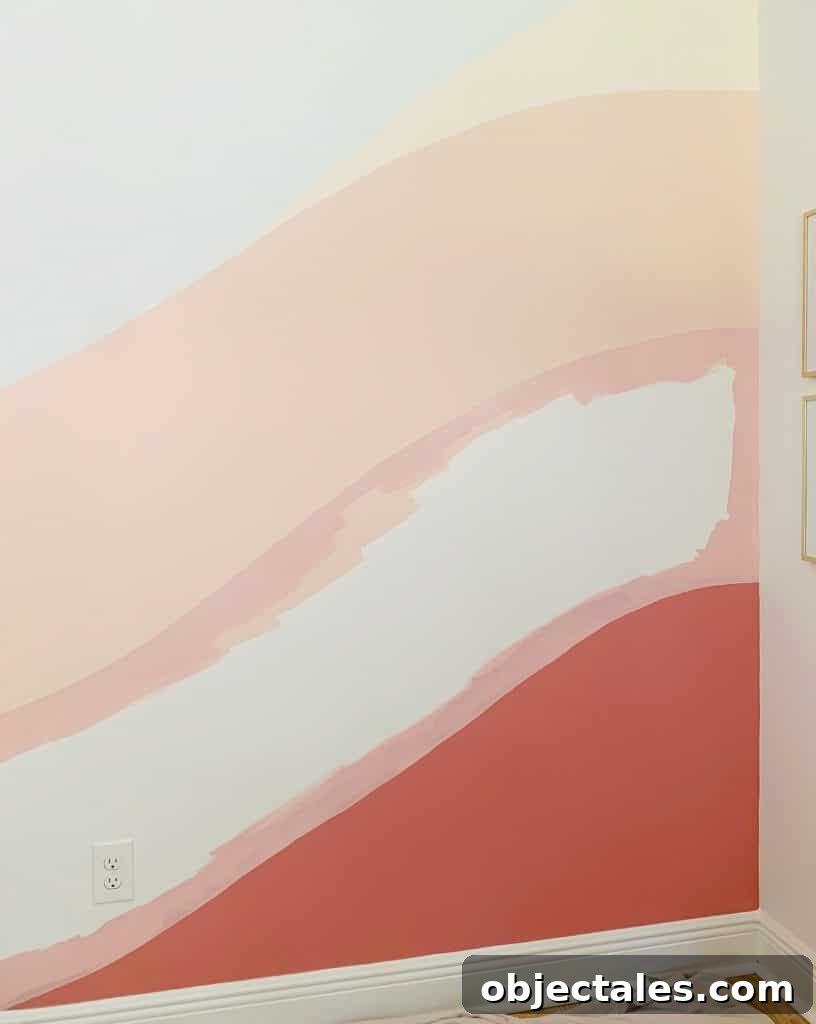 Crisp edges of pink paint between two colors on abstract wall mural