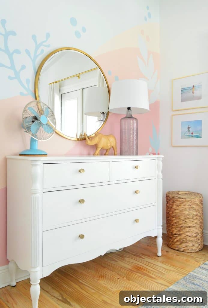 Beachy abstract mural in girls bedroom with traditional dresser and gold mirror