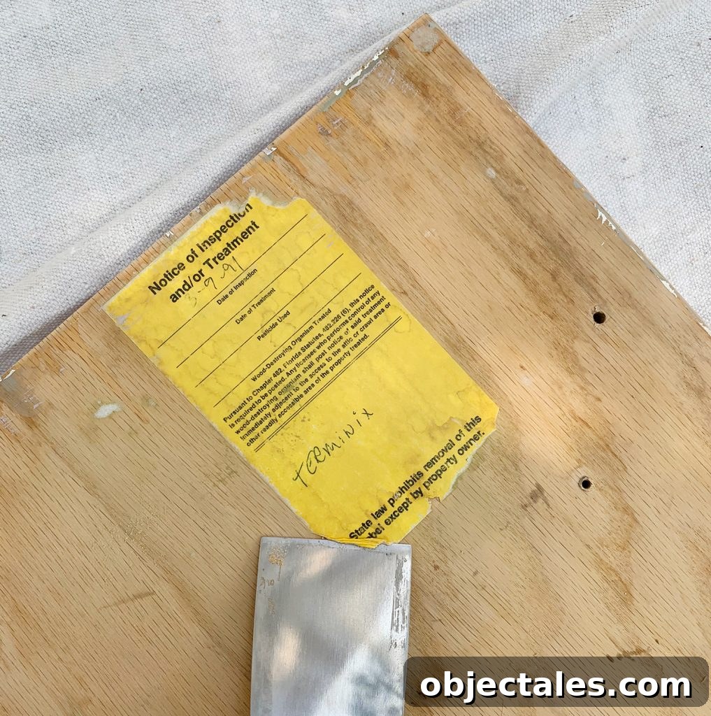 Before and After: Pink Kitchen Cabinets Makeover 11 Scraping old label off the back of kitchen cabinets as painting prep