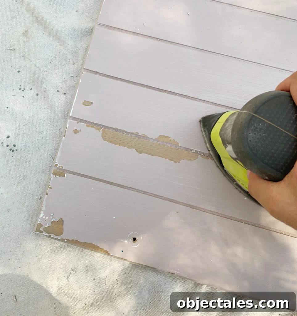 How to Paint Kitchen Cabinets Pink: Tips and Color Ideas 12 Sanding old paint drips off of wood cabinets in preparation for cabinet painting
