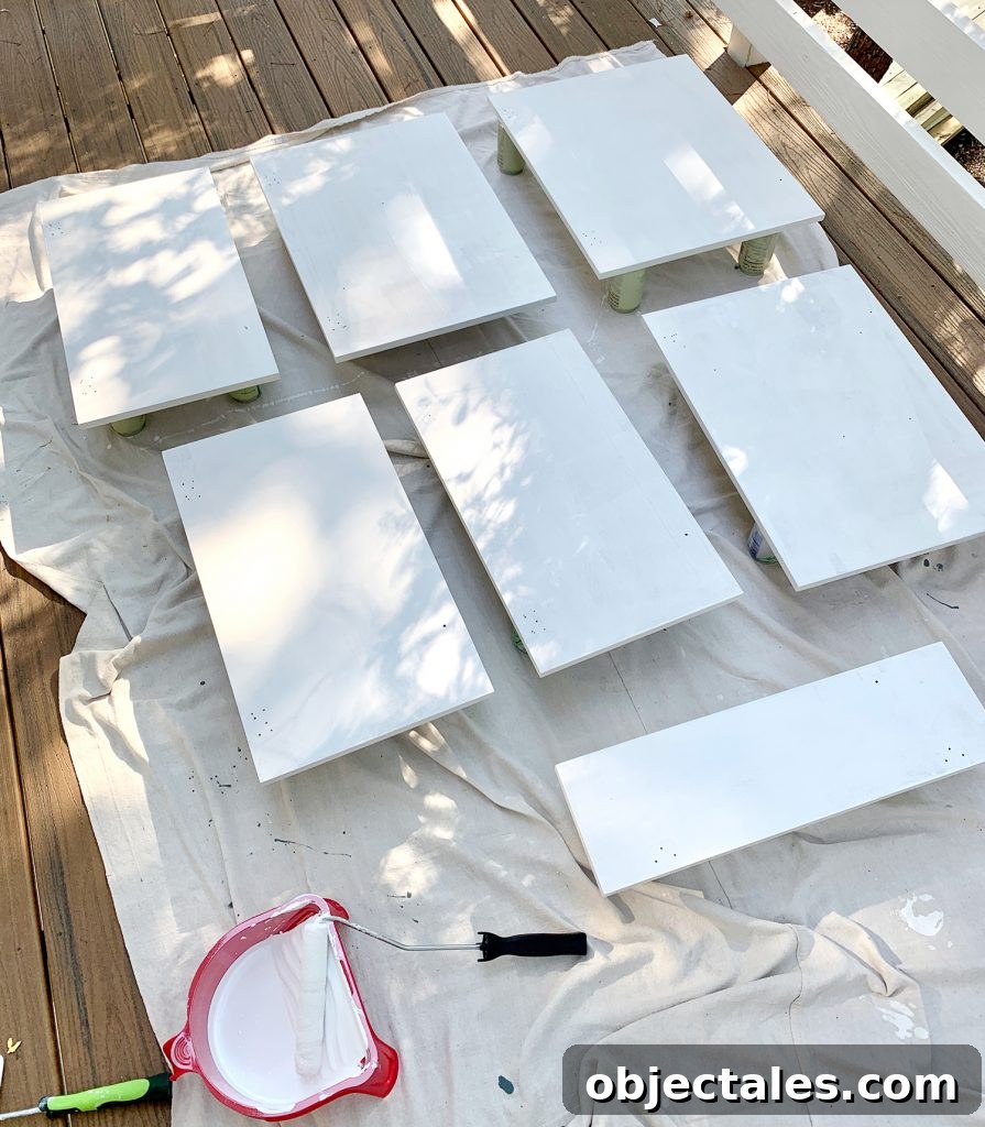 Before and After: Pink Kitchen Cabinets Makeover 13 Cabinet doors laid on drop cloth with coat of white primer drying
