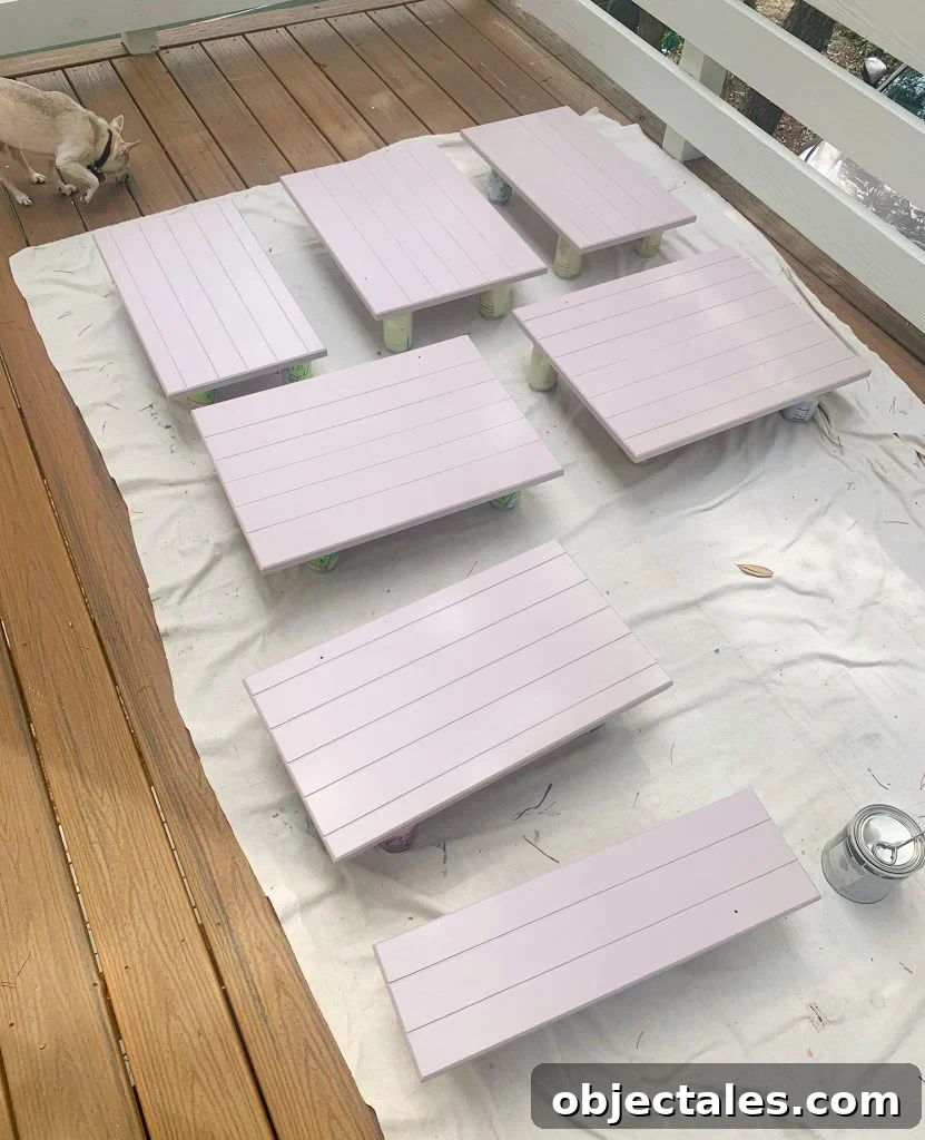 How to Paint Kitchen Cabinets Pink: Tips and Color Ideas 14 Wood cabinet doors on drop cloth drying with coat of mauve paint