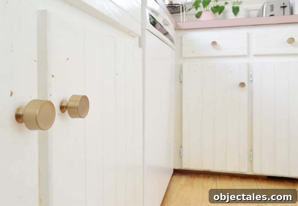 How to Paint Kitchen Cabinets Pink: Tips and Color Ideas 18 Close up before photo of white cabinets with paint flecks near knobs