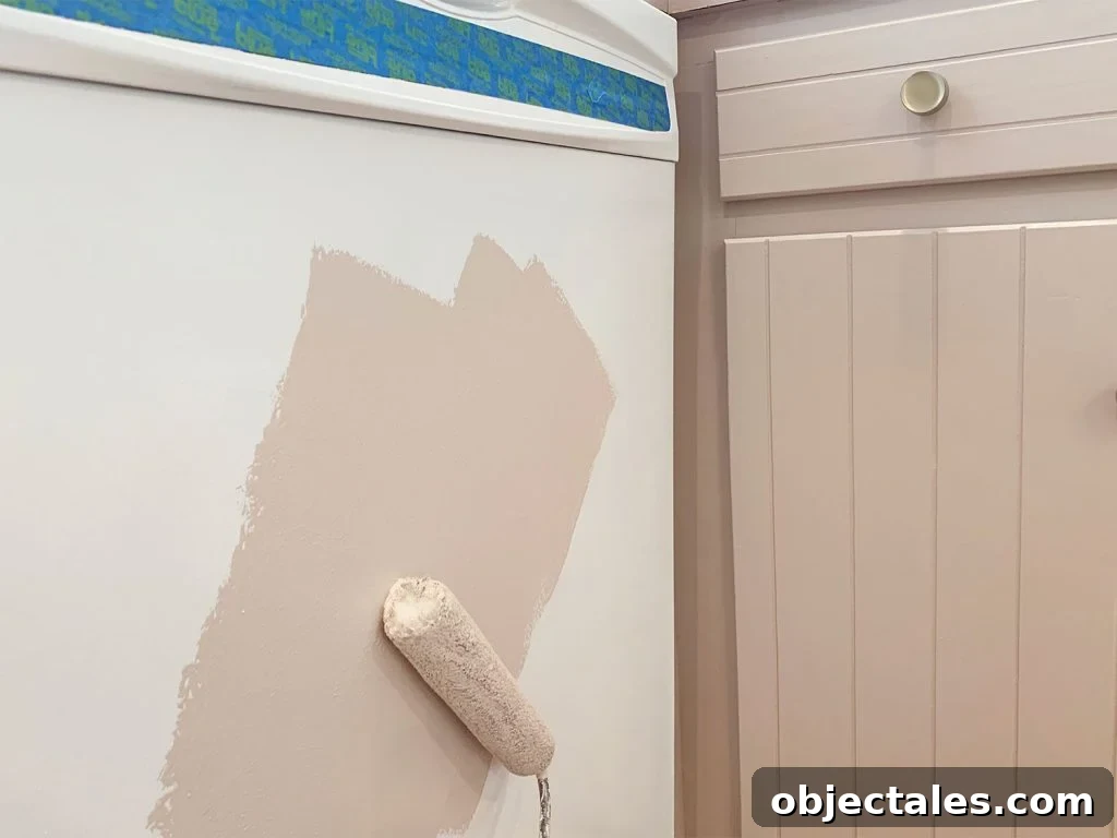 How to Paint Kitchen Cabinets Pink: Tips and Color Ideas 21 Rolling mauve paint onto white dishwasher using small foam roller