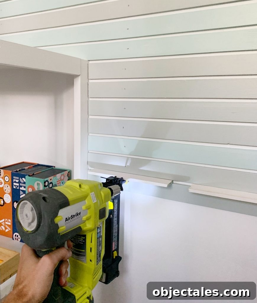 How to Create a Colorful Wood Accent Wall 13 Nail Gun Attaching Smaller Lattice Pieces Onto Wall Next To Bookshelf