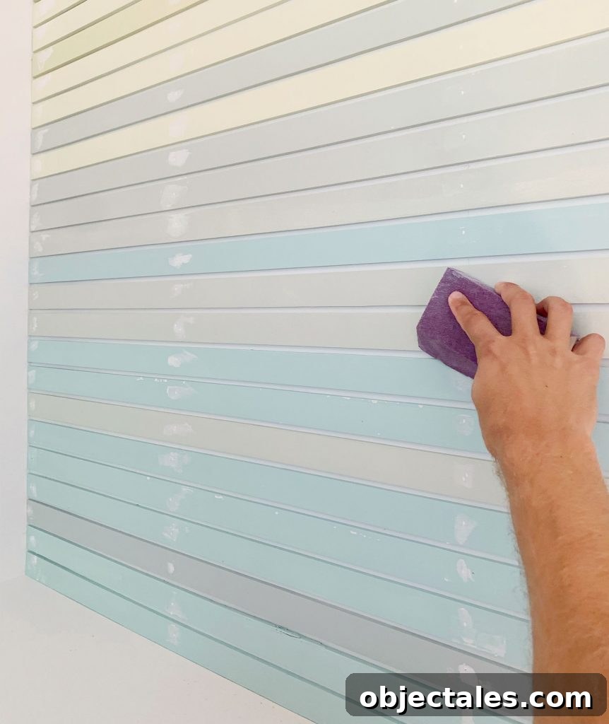 How to Create a Colorful Wood Accent Wall 17 Hand Sanding Spackled Holes On Striped Wall Treatment