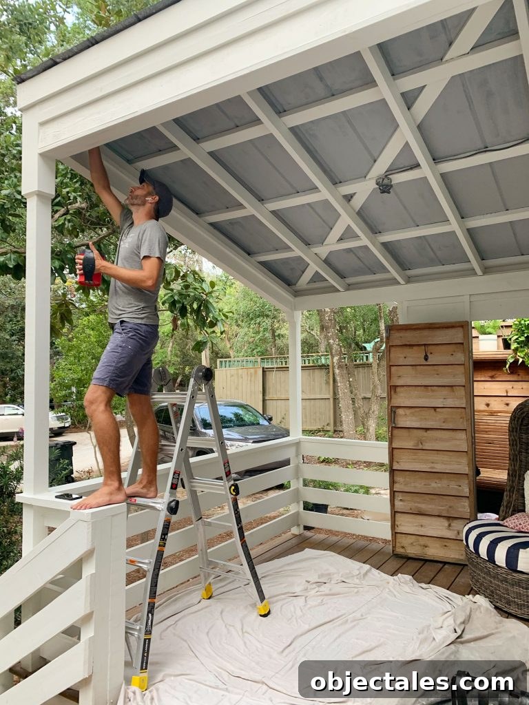 John Standing On Ladder Priming Metal Porch Ceiling
