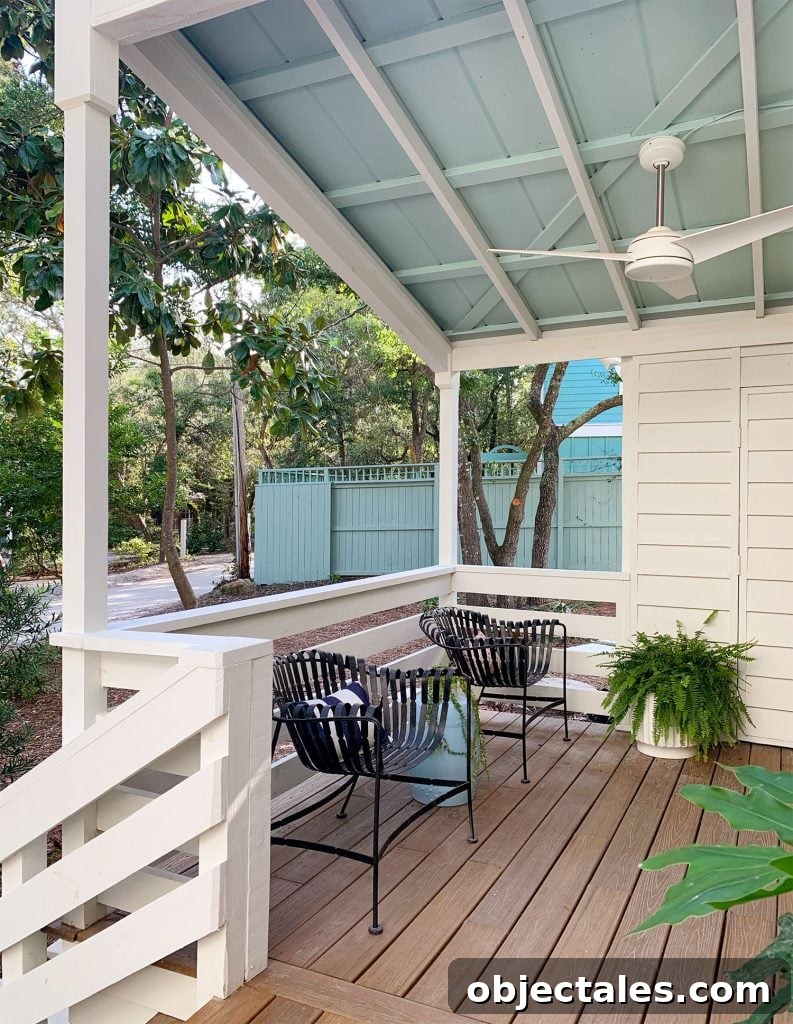 Blue Ceiling On Covered Porch With Ceiling Fan And Black Chairs