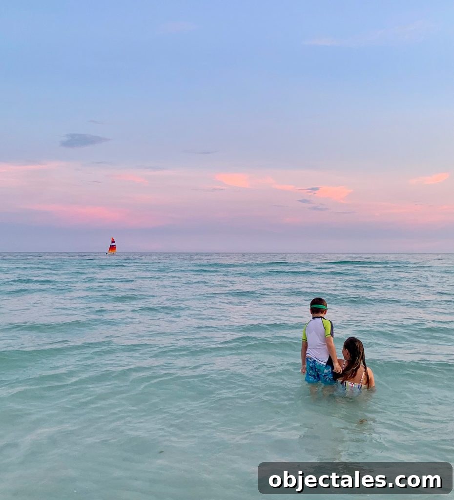 Downsizing: What to Expect and How It Feels 10 Kids playing in Gulf of Mexico at sunset with sailboat in background