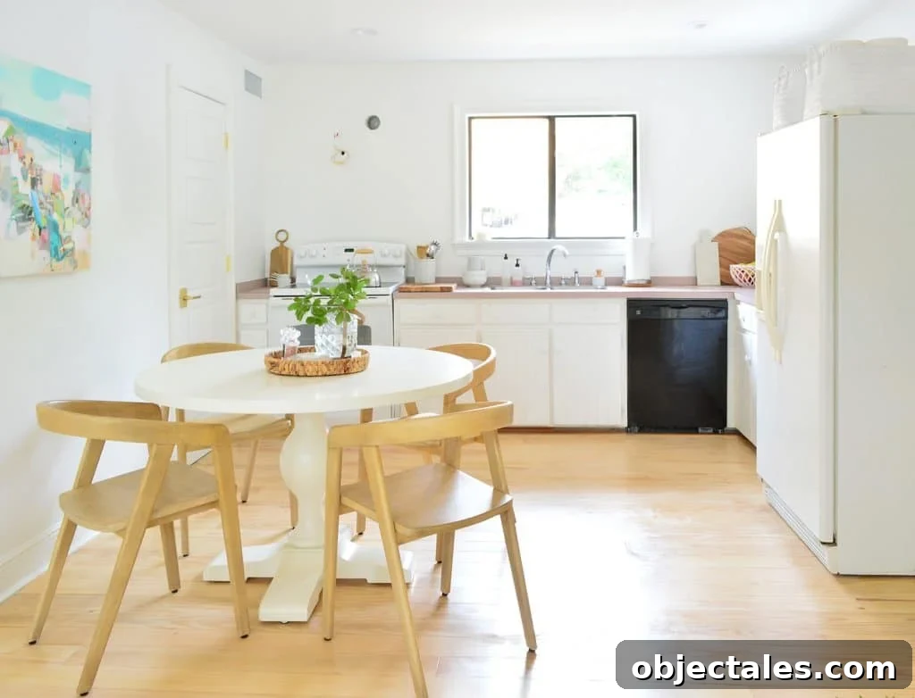 Six Months In: Our Kitchen and Sitting Area 4 Kitchen with white cabinets black dishwasher and off center round table