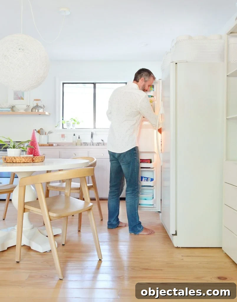 Six Months In: Our Kitchen and Sitting Area 10 John standing with freezer door open next to round table in kitchen