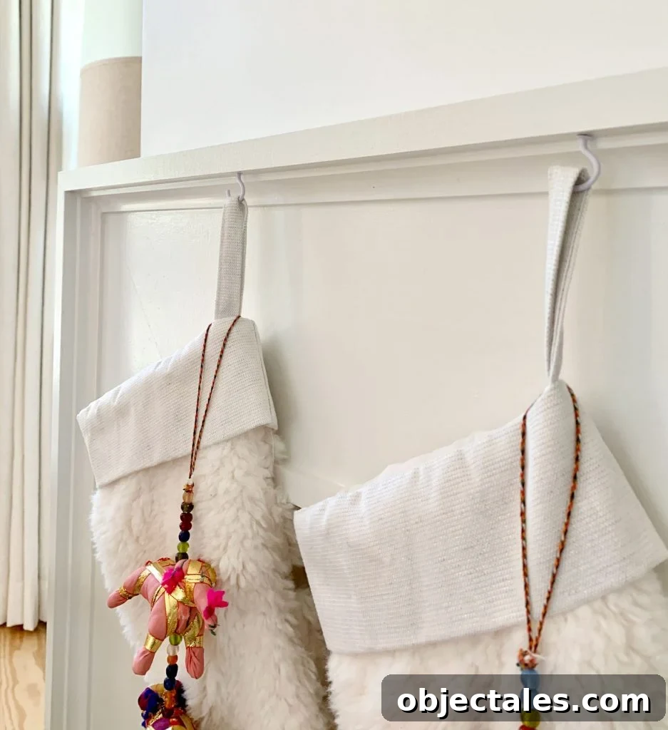Close up detail of stockings hanging from mantel using small white cup hooks