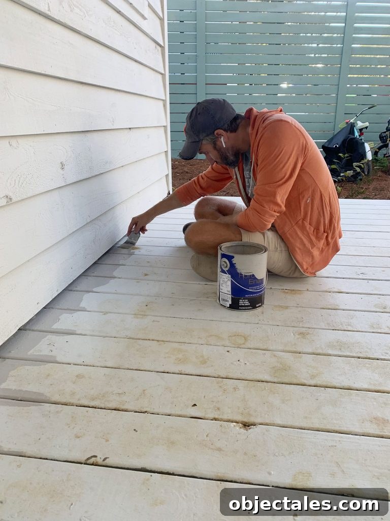 How to Paint a Porch Floor: Prep, Paint, and Finish 5 John edging porch floor with gray floor paint on paintbrush