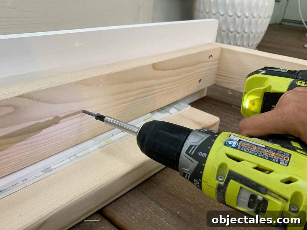 Build a Hanging Daybed: Step-by-Step DIY Tutorial 11 Screwing 2x4 wood frame to white 1x8 board