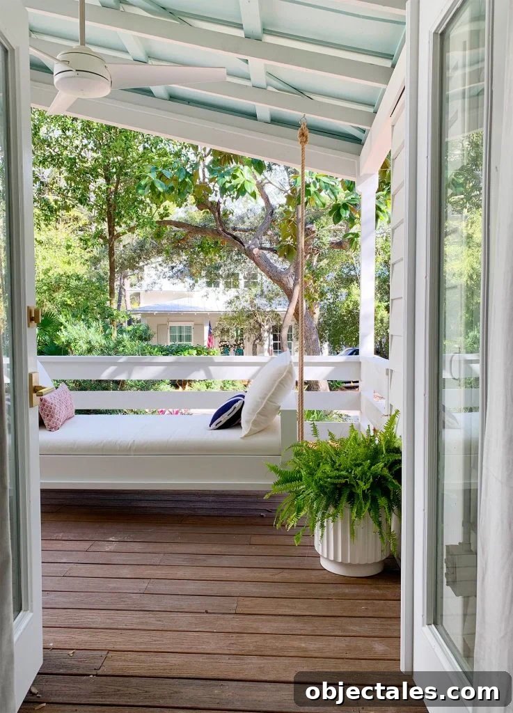 Build a Hanging Daybed: Step-by-Step DIY Tutorial 22 View Of White Hanging Daybed Swing Under Covered Porch Through Open French Doors
