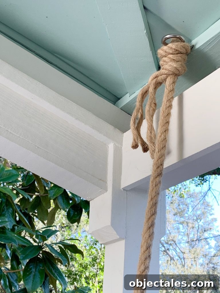 Rope knotted around screw eye hook in ceiling of covered porch