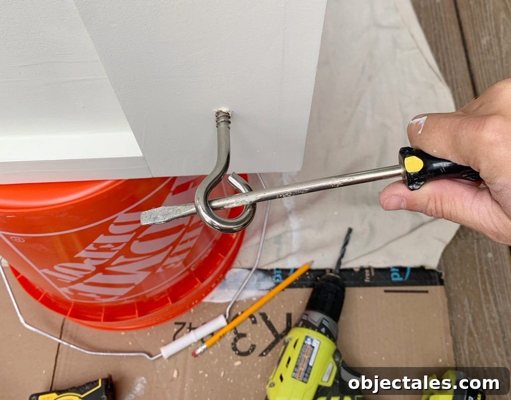 Turning eyehook in hanging daybed using long screwdriver