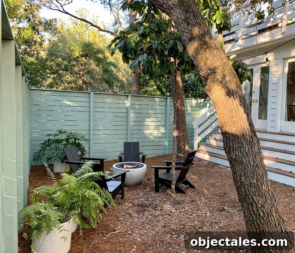 Create a Cozy Fire Pit Area for Outdoor Gatherings 2 Green fenced side yard with black Adirondack chairs around fire pit